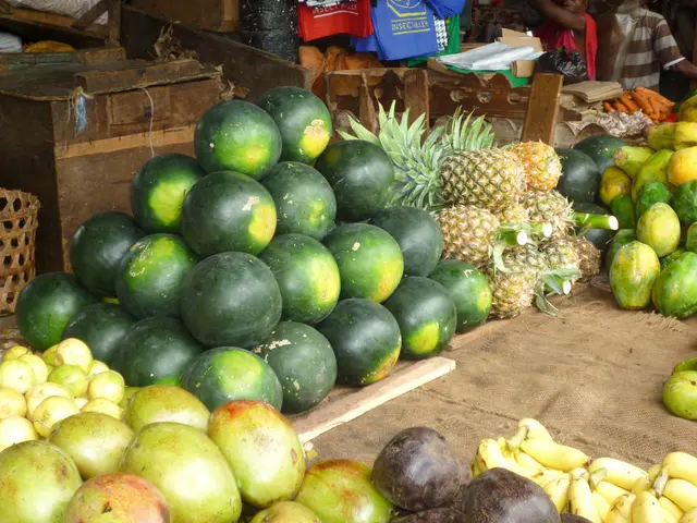 In the image there are watermelons, pineapples, papaya, carrot, t-shirts and in the background...