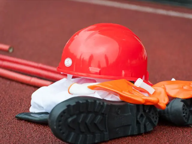 In this image we can see helmet, a pair of shoes, a pair of gloves and sticks placed on the floor.