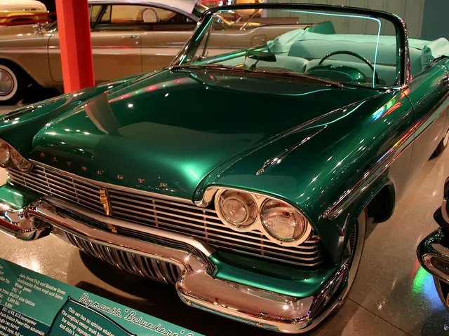 In this image we can see some vehicles in a room and there is a board with some text.